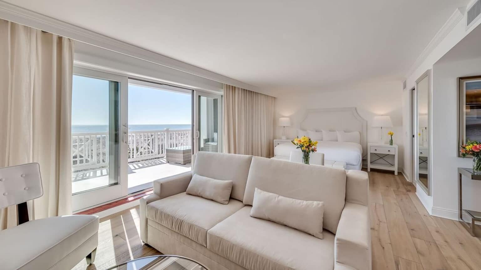 Living room area, balcony doors, and king bed in the Oceanfront luxury king studio