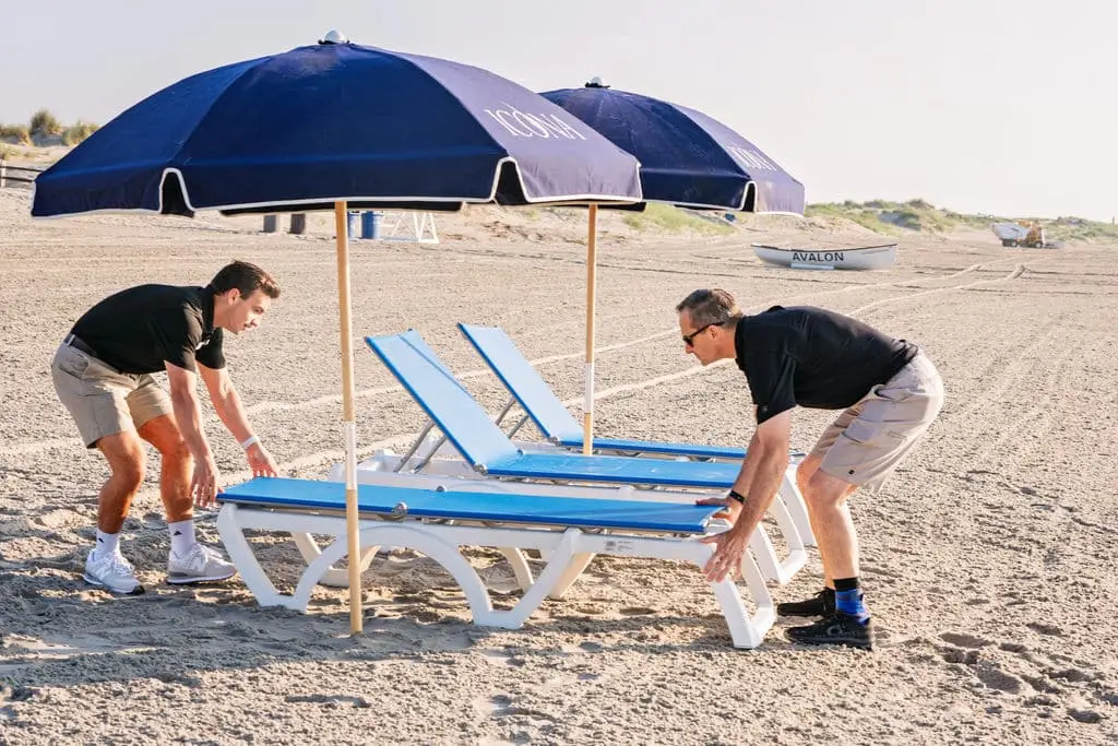 ICONA employees placing lounge chairs on the beach
