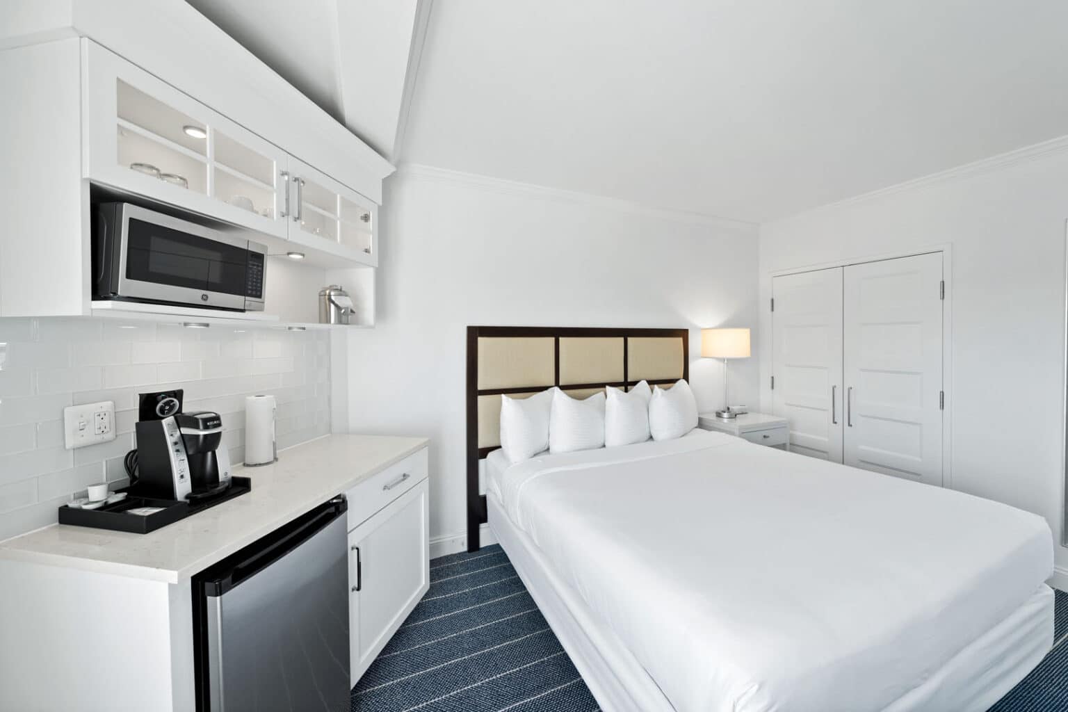 Classic king hotel room bed and mini-fridge