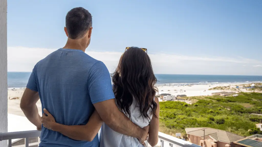 Couple taking in the ocean view from their balcony at ICONA Diamond Beach