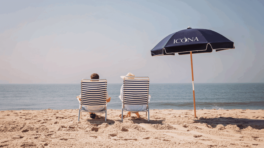 Couple sitting on the beach in ICONA beach chairs