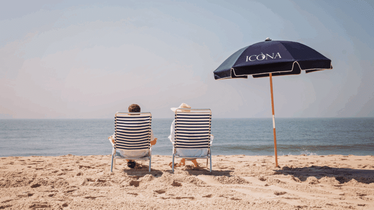 Couple sitting on the beach in ICONA beach chairs