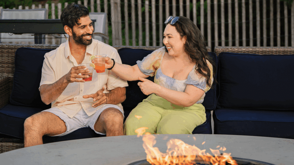 Couple enjoying drinks by a fire pit