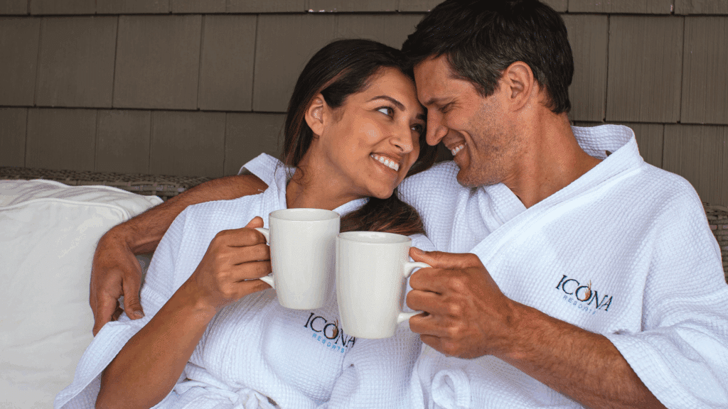 A couple in ICONA robes curling up on a porch at an ICONA Resort