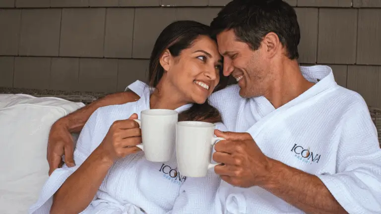 A couple in ICONA robes curling up on a porch at an ICONA Resort
