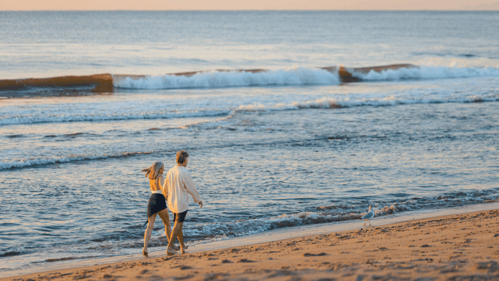 Couple walking along the ocean at the beach in Spring Lake, NJ
