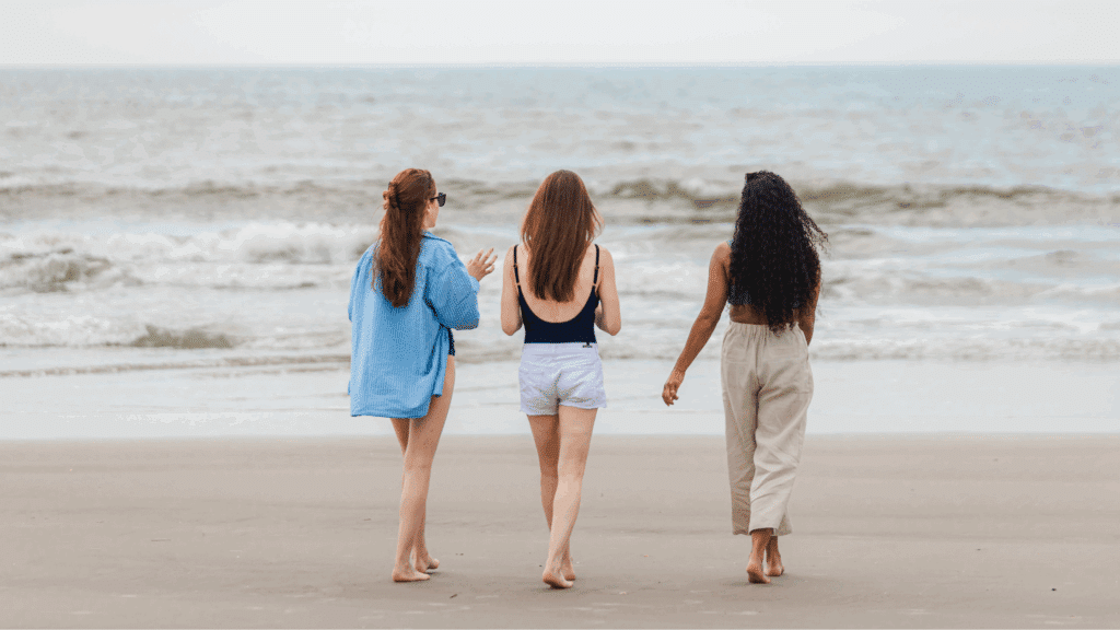 Three women walking on Wildwood beach together.