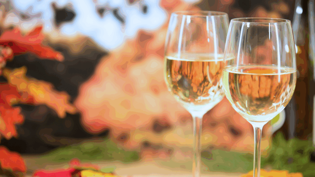 Two glasses of wine with a backdrop of fall foliage
