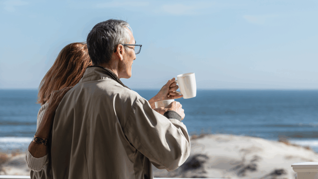 Couple looking out over the ocean while drinking coffee at ICONA Avalon