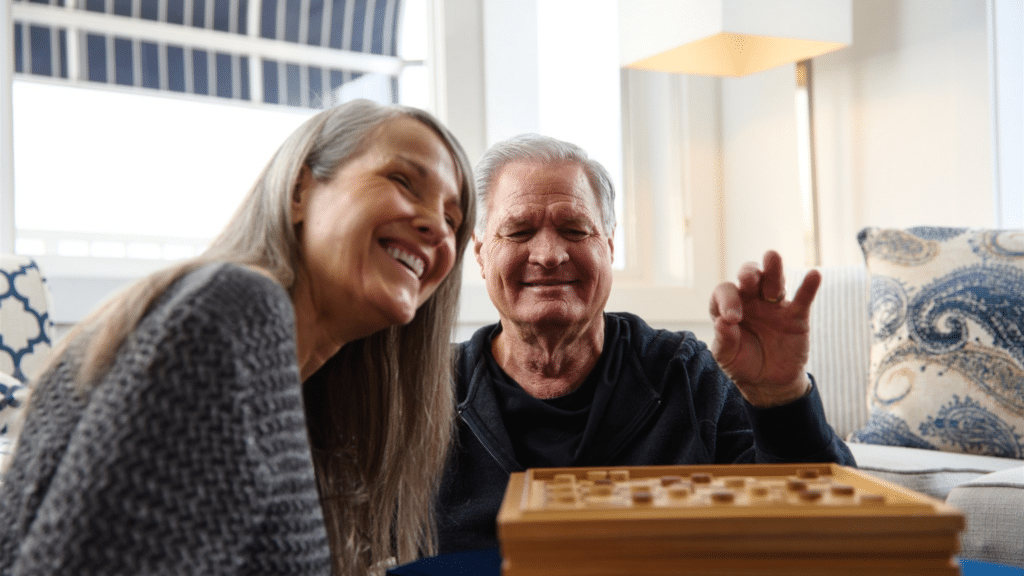 Couple playing checkers in their hotel room at ICONA Cape May