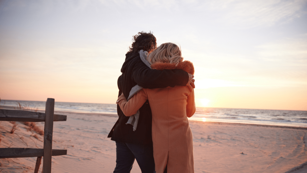 Couple walking on the beach at sunrise