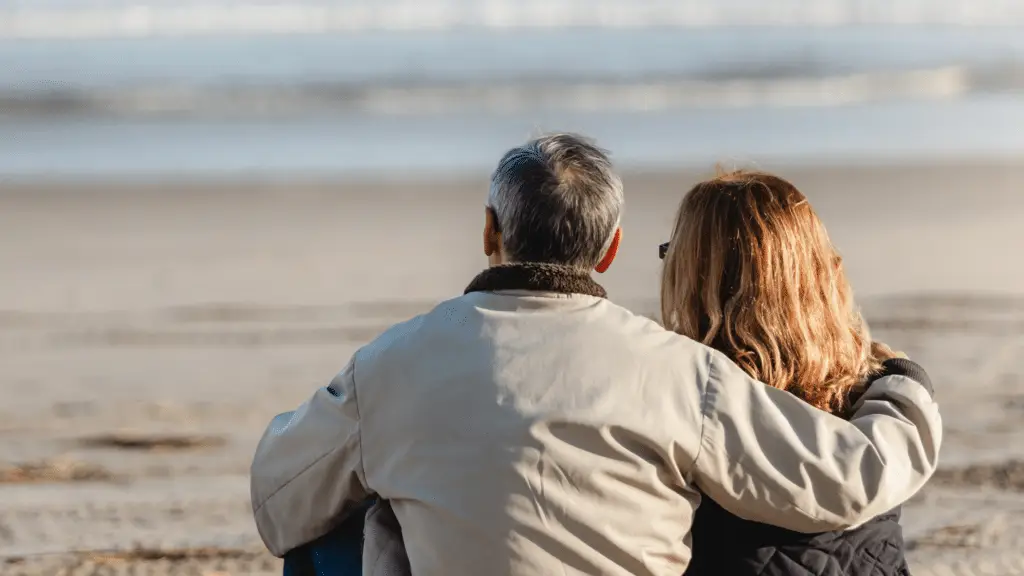 Couple sitting together on the beach during a romantic beach getaway