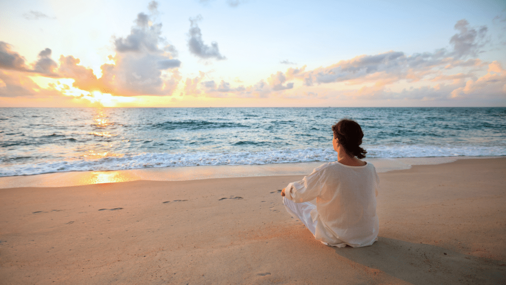 Woman meditating on the beach