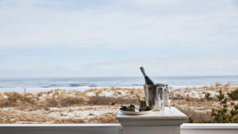 Champagne and chocolate covered strawberries in front of the ocean