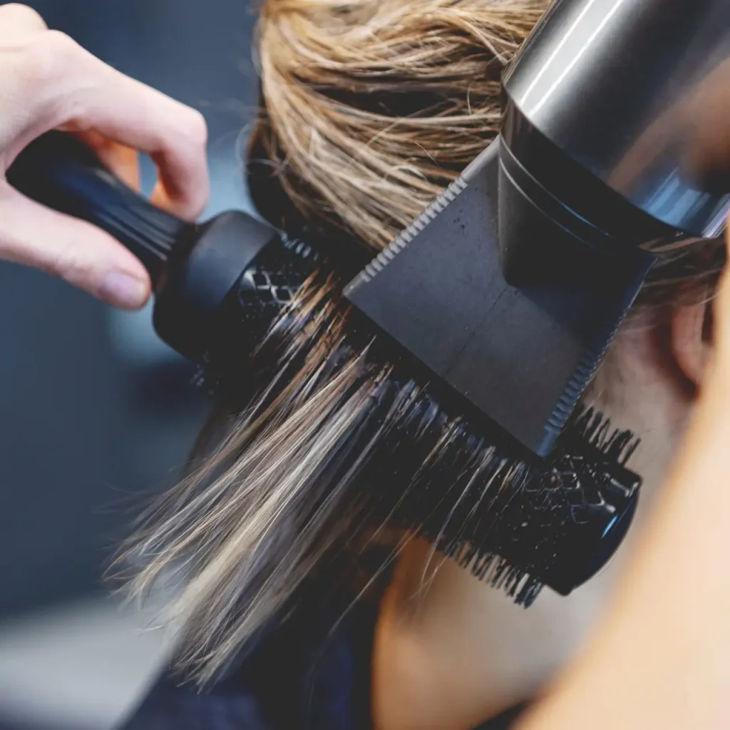 Hair,Of,Female,Client,Straightened,With,Blow,Dryer,And,Round